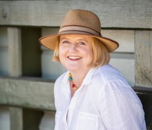 Cathryn Hein author wearing a white shirt and tan hat